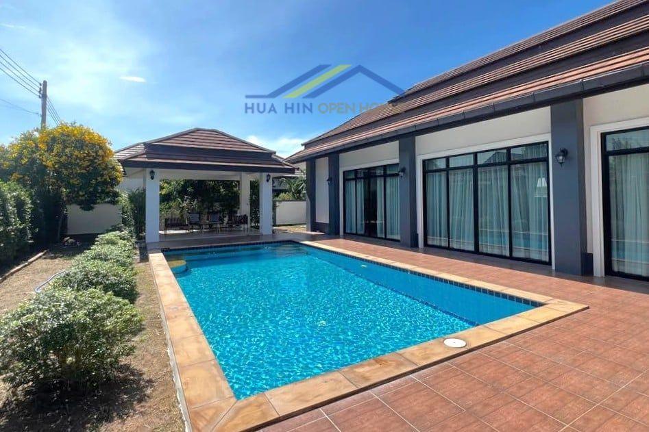 Spacious pool villa with a sala, surrounded by greenery in Hin Lek Fai, Hua Hin, featuring large windows and sunlit patio.