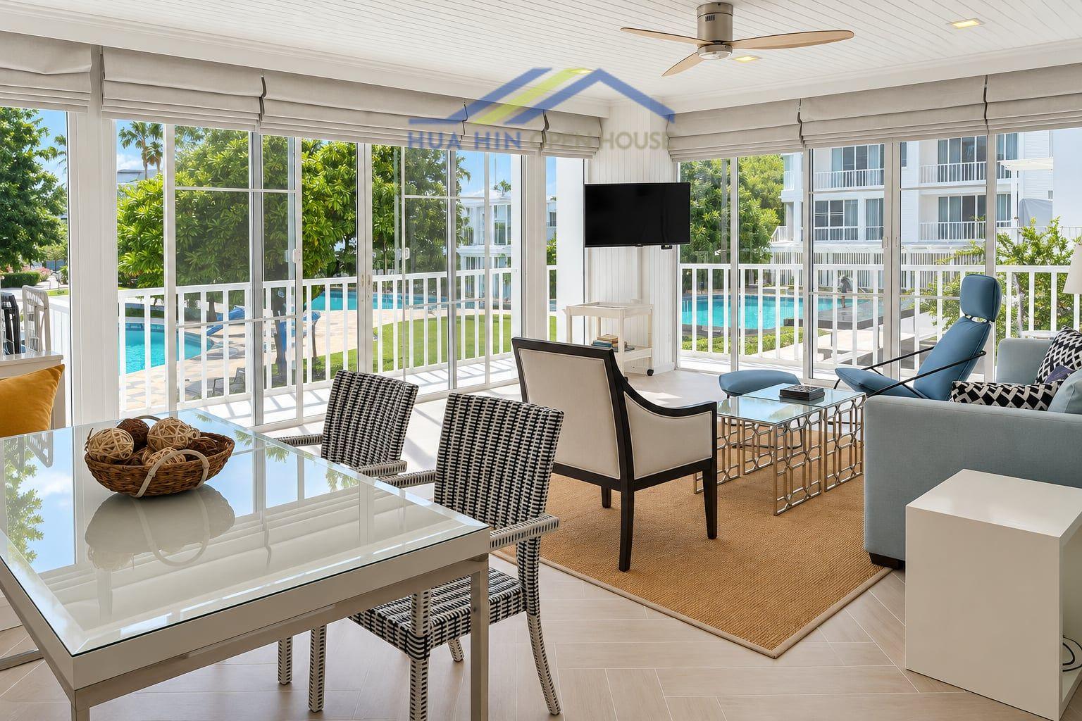 Bright and airy living area with pool view, featuring modern furnishings and a dining table at Malibu Khao Tao condo.