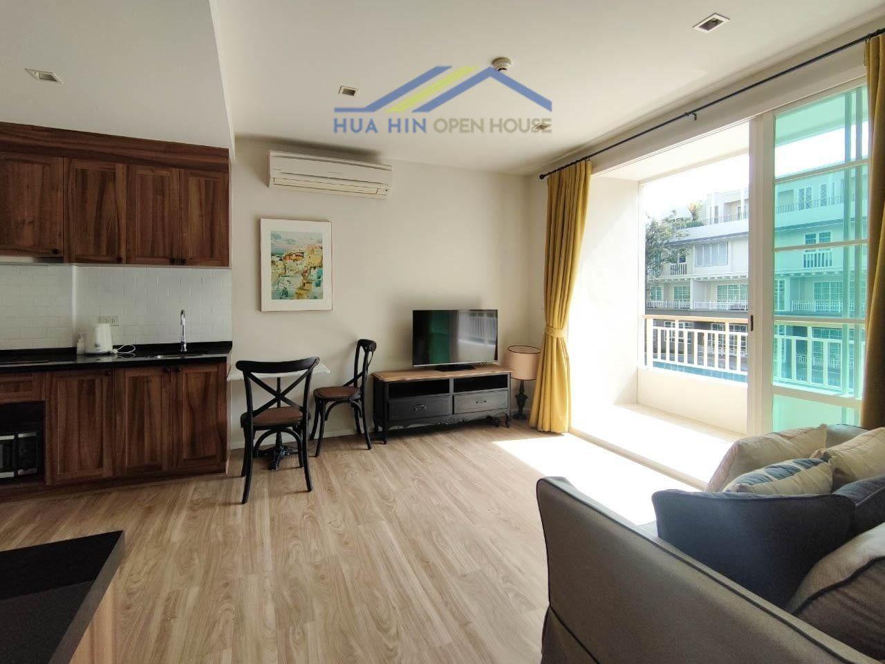 Spacious, fully furnished condo with modern kitchen, living area, and large windows for natural light. Close to Khao Takiab B