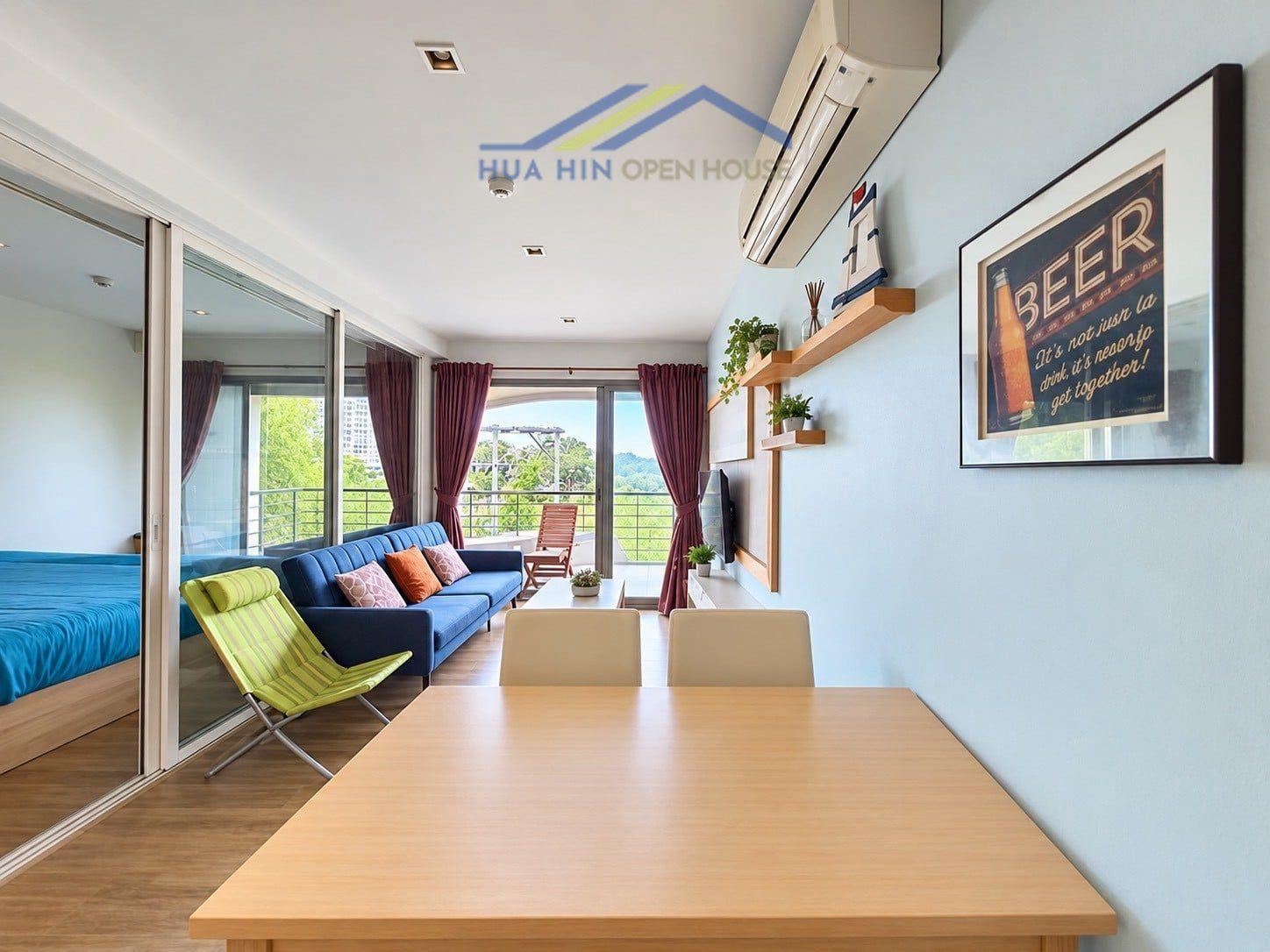 Bright and modern beachfront condo interior featuring a living area, dining table, and balcony access.