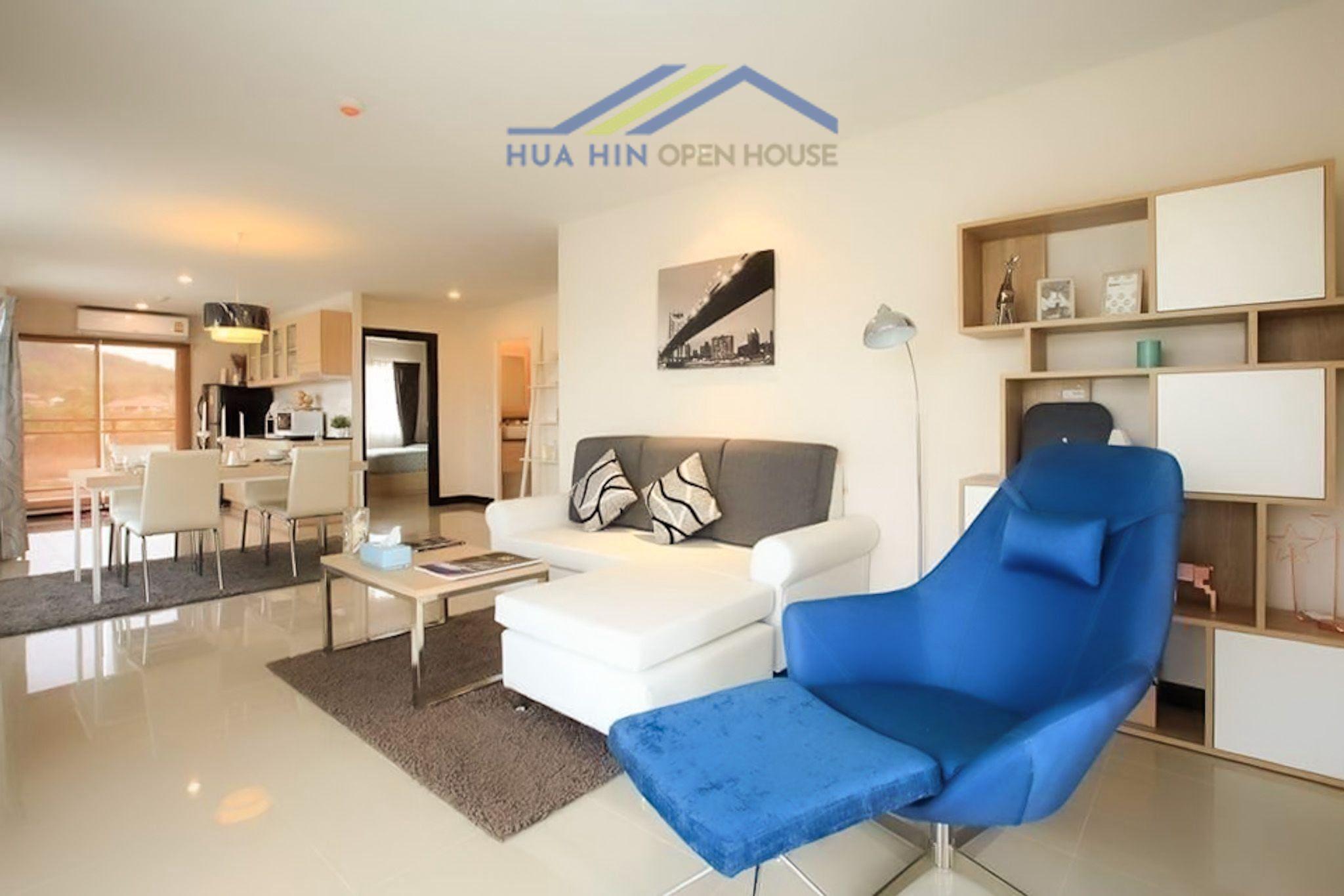 Stylish living area in a 2-bedroom corner condo, featuring modern furniture and mountain views through large windows.