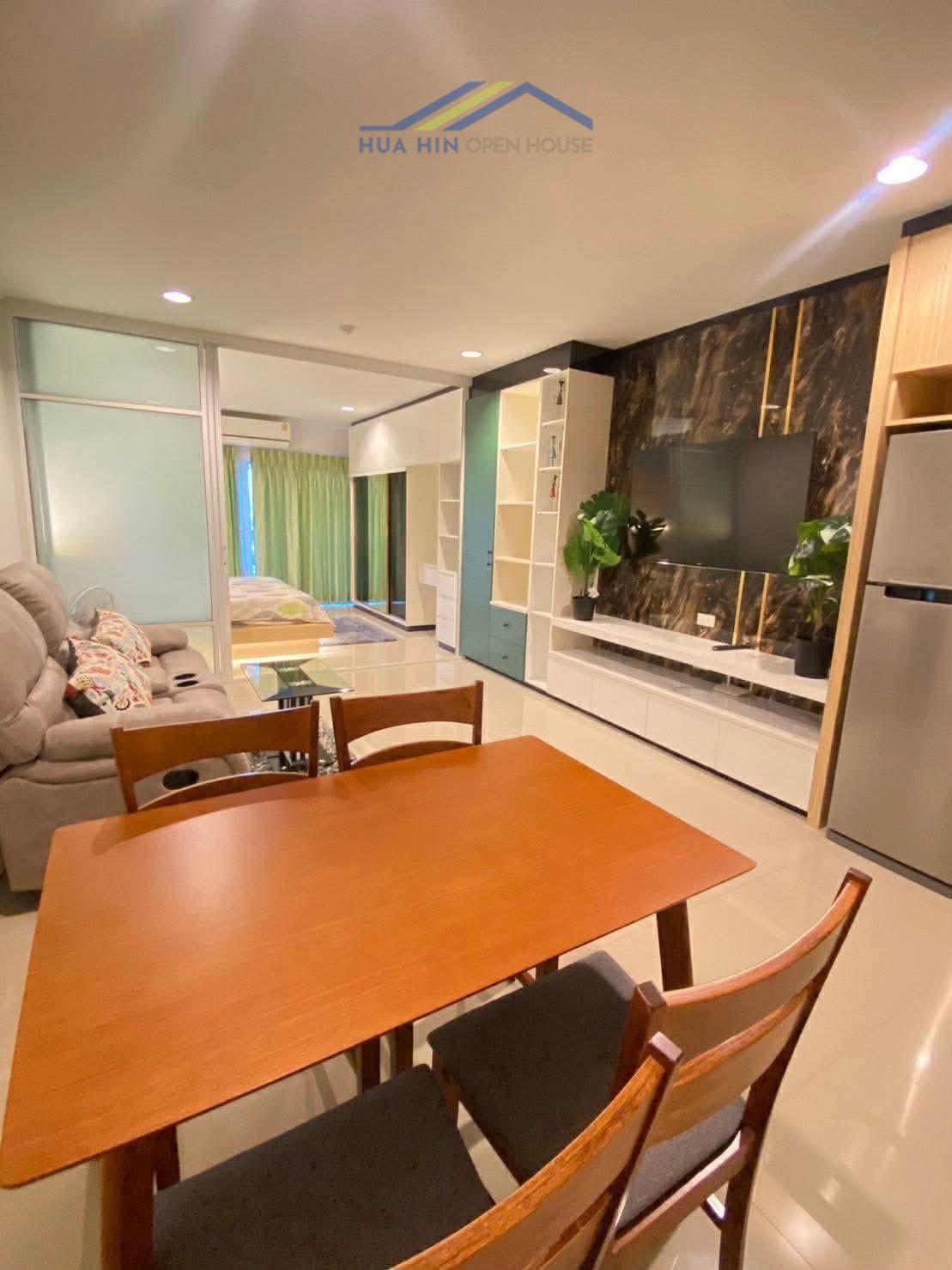 Modern 1-bedroom condo interior featuring a dining table, cozy seating area, and stylish decor in Hua Hin.
