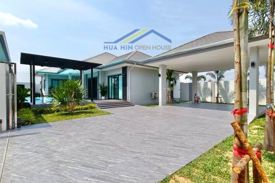 Modern 3-bedroom pool villa with landscaped garden and spacious driveway for sale in Hua Hin, Thailand.