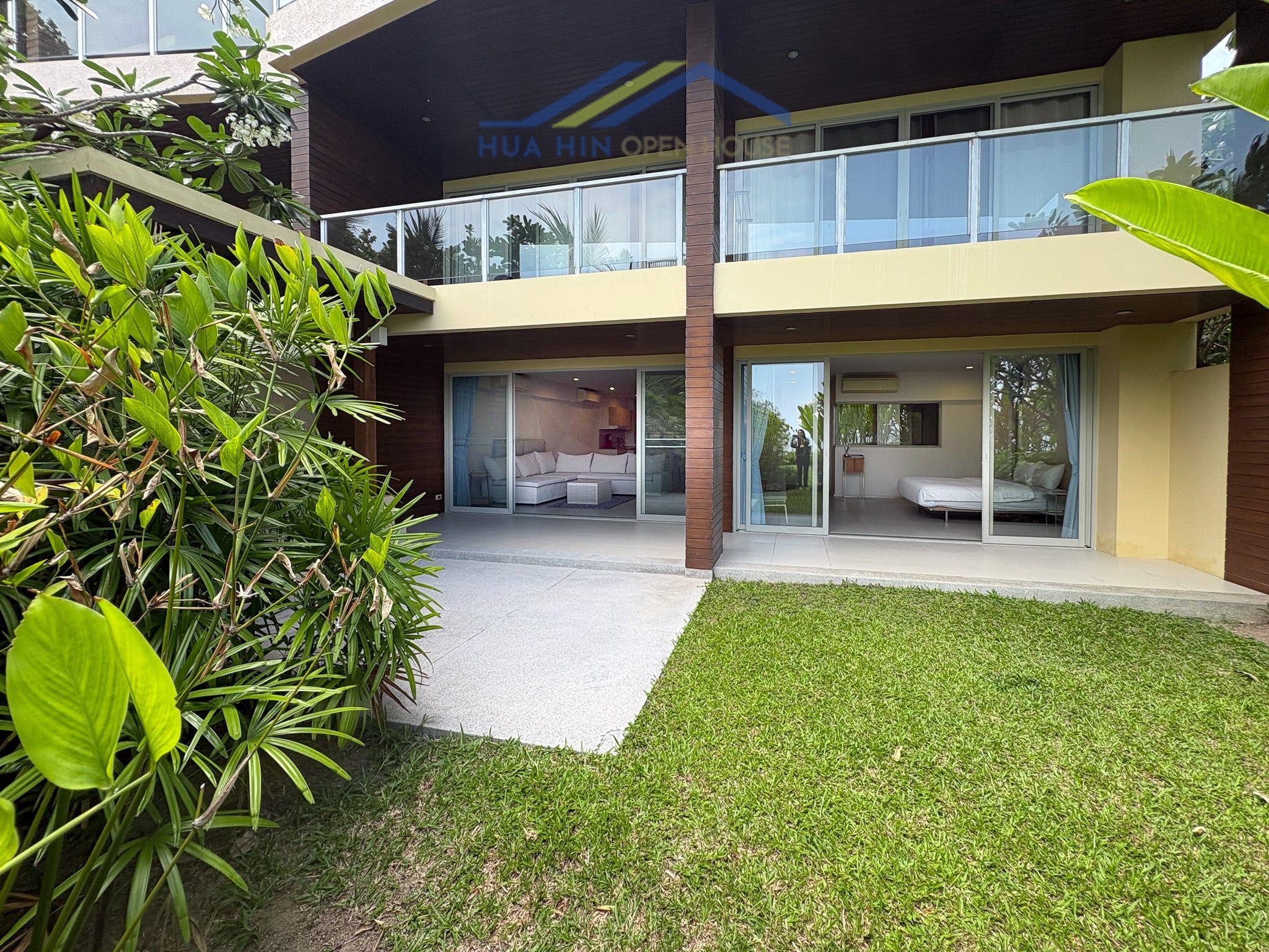 Ground floor beachfront condo at Baan Thew Talay Aquamarine, featuring a private patio and lush greenery.