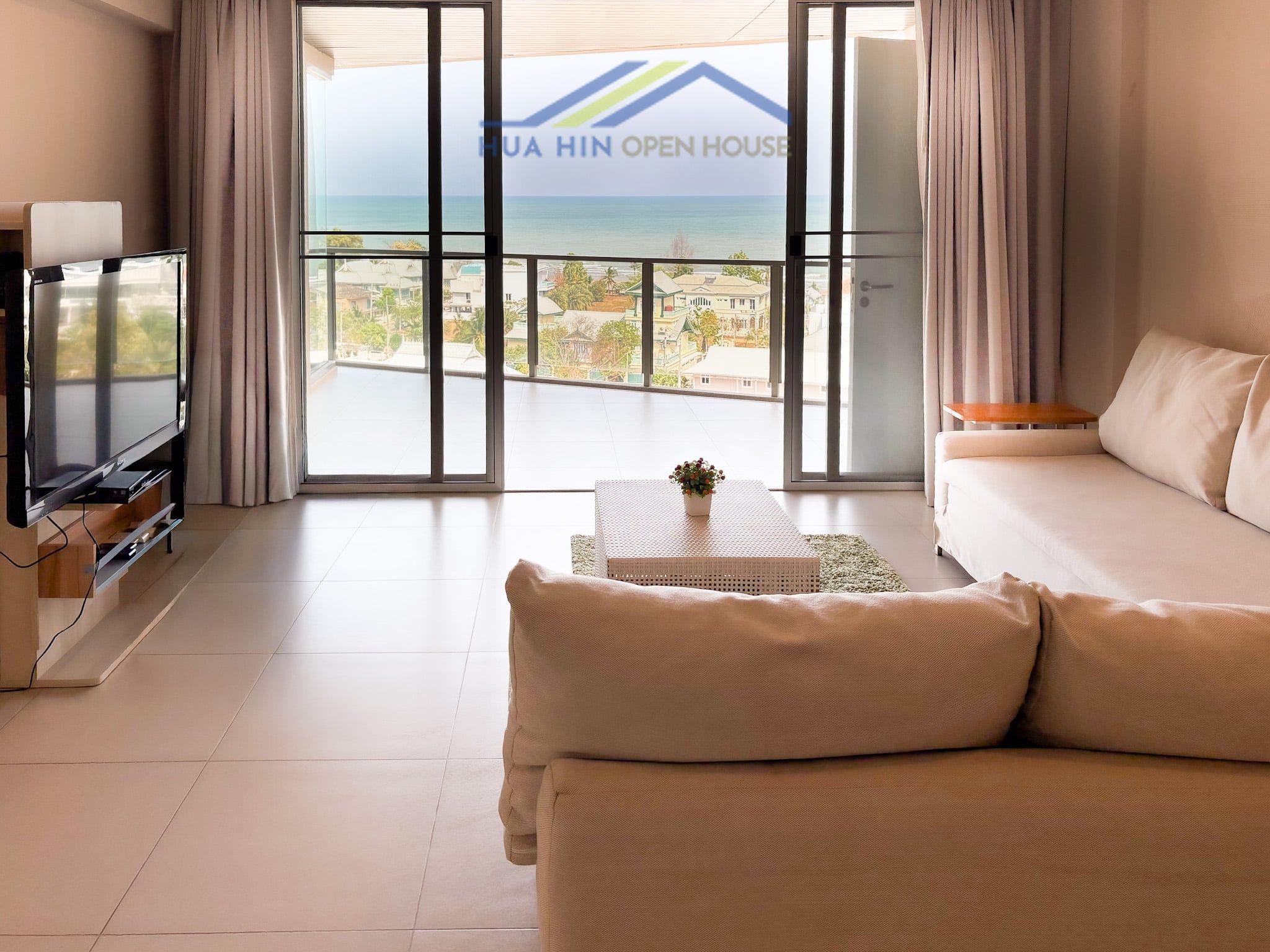 Spacious living area with modern furnishings, large windows showcasing stunning sea views in a 3-bedroom condo.