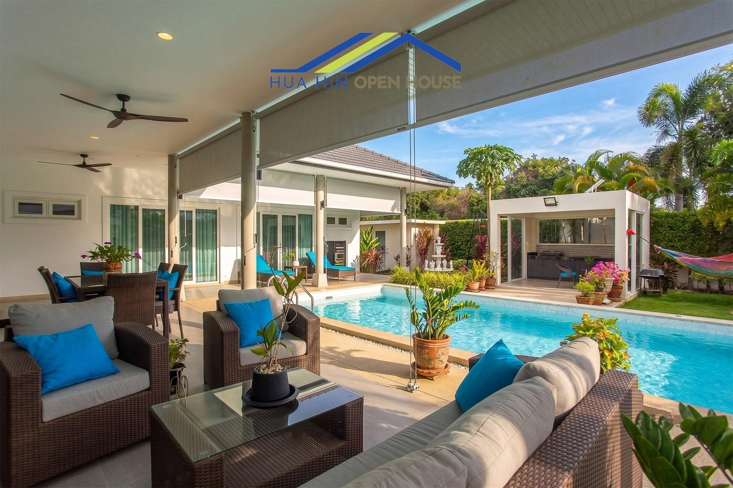 Nantra Hua Hin outdoor living area with a pool, lounge seating, and tropical landscaping in a solar pool villa.