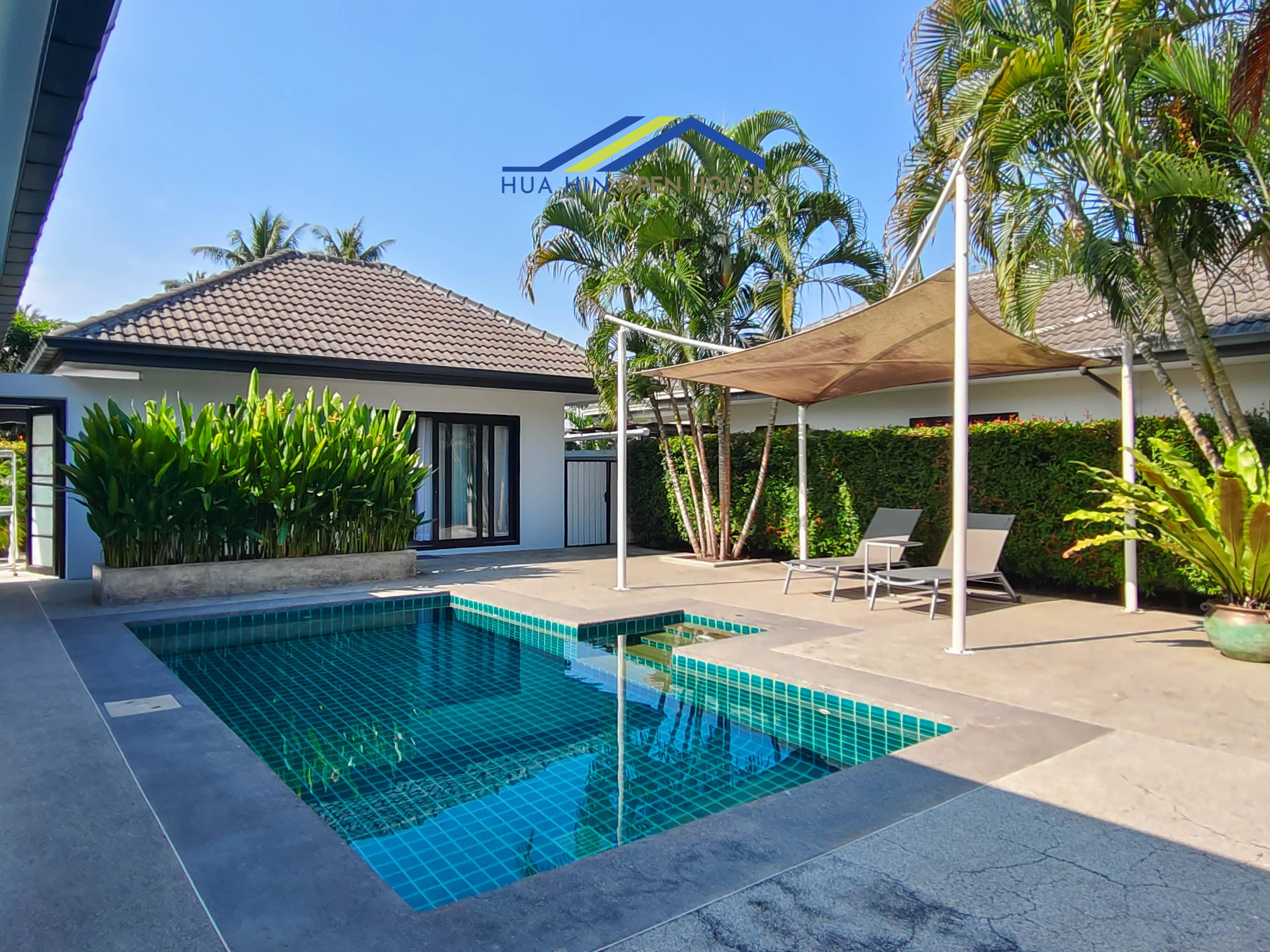 Private pool villa in Hin Lek Fai with lush greenery, sun loungers, and a shaded area for relaxation.