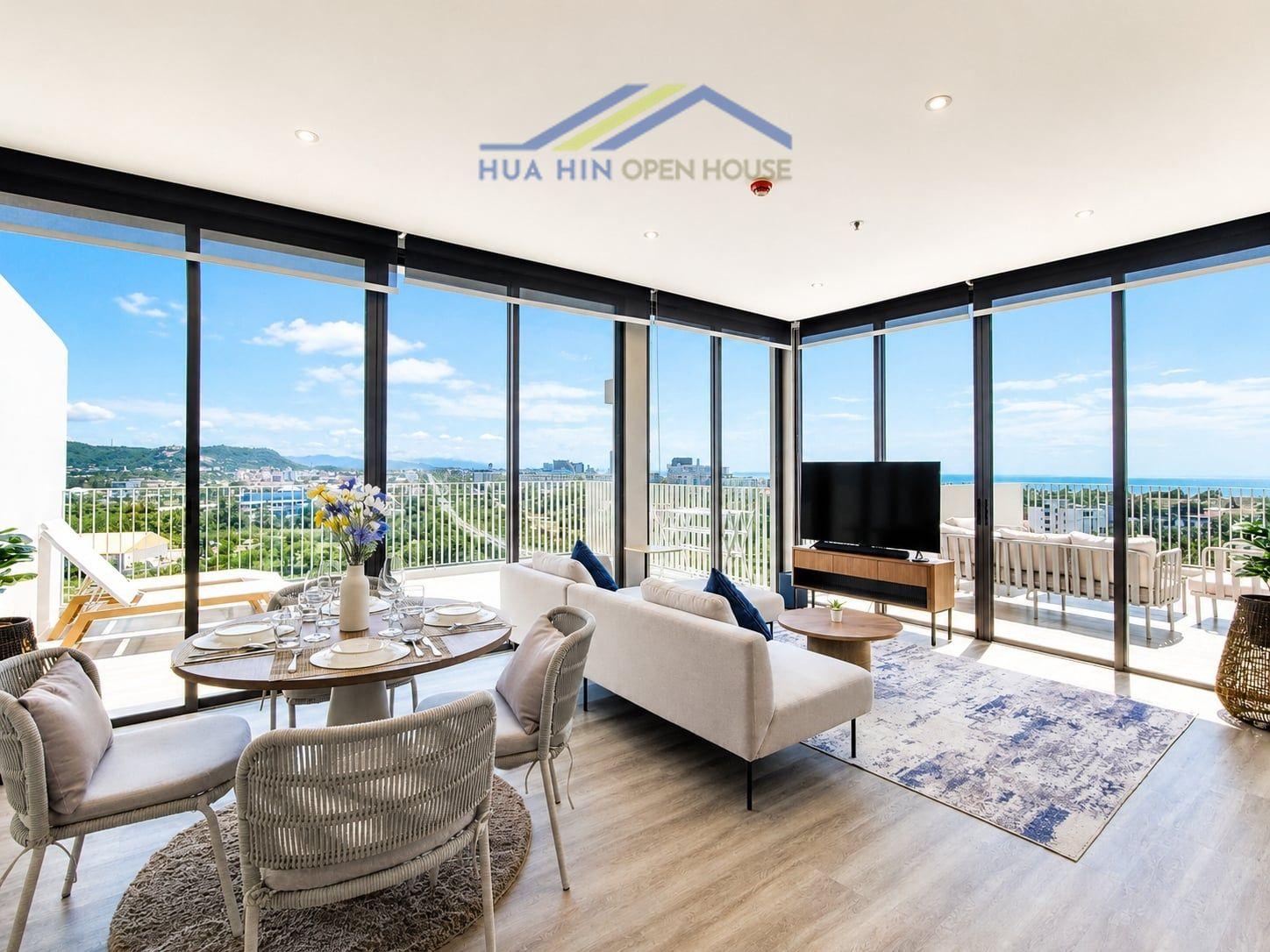 Bright corner condo featuring panoramic sea and mountain views, modern furnishings, and a dining area with a stylish table.