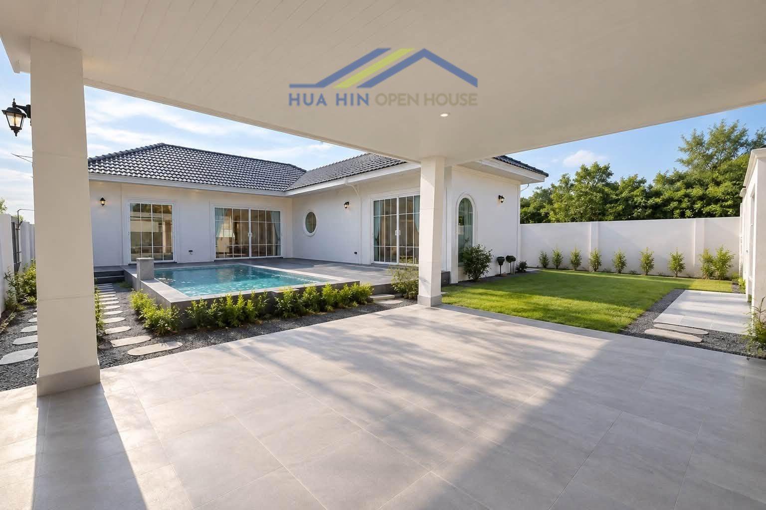 Modern pool villa with spacious patio, lush garden, and large windows in Hua Hin, ideal for outdoor living.