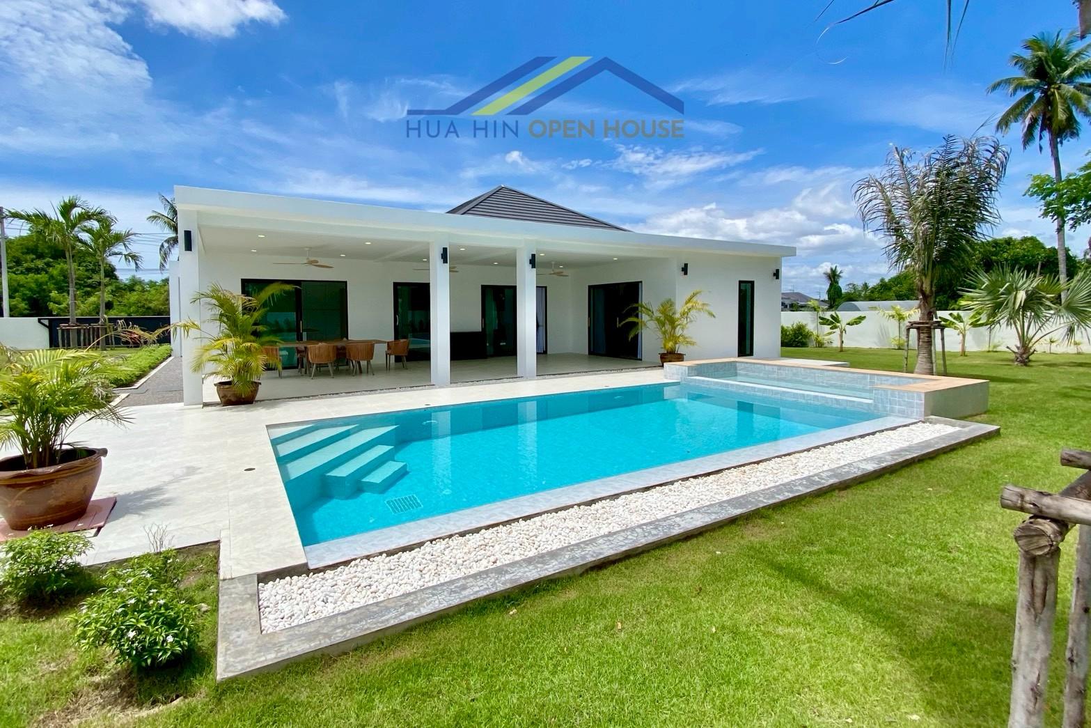 Modern villa with a private pool and spacious garden, featuring outdoor seating and lush greenery in Hin Lek Fai, Hua Hin.