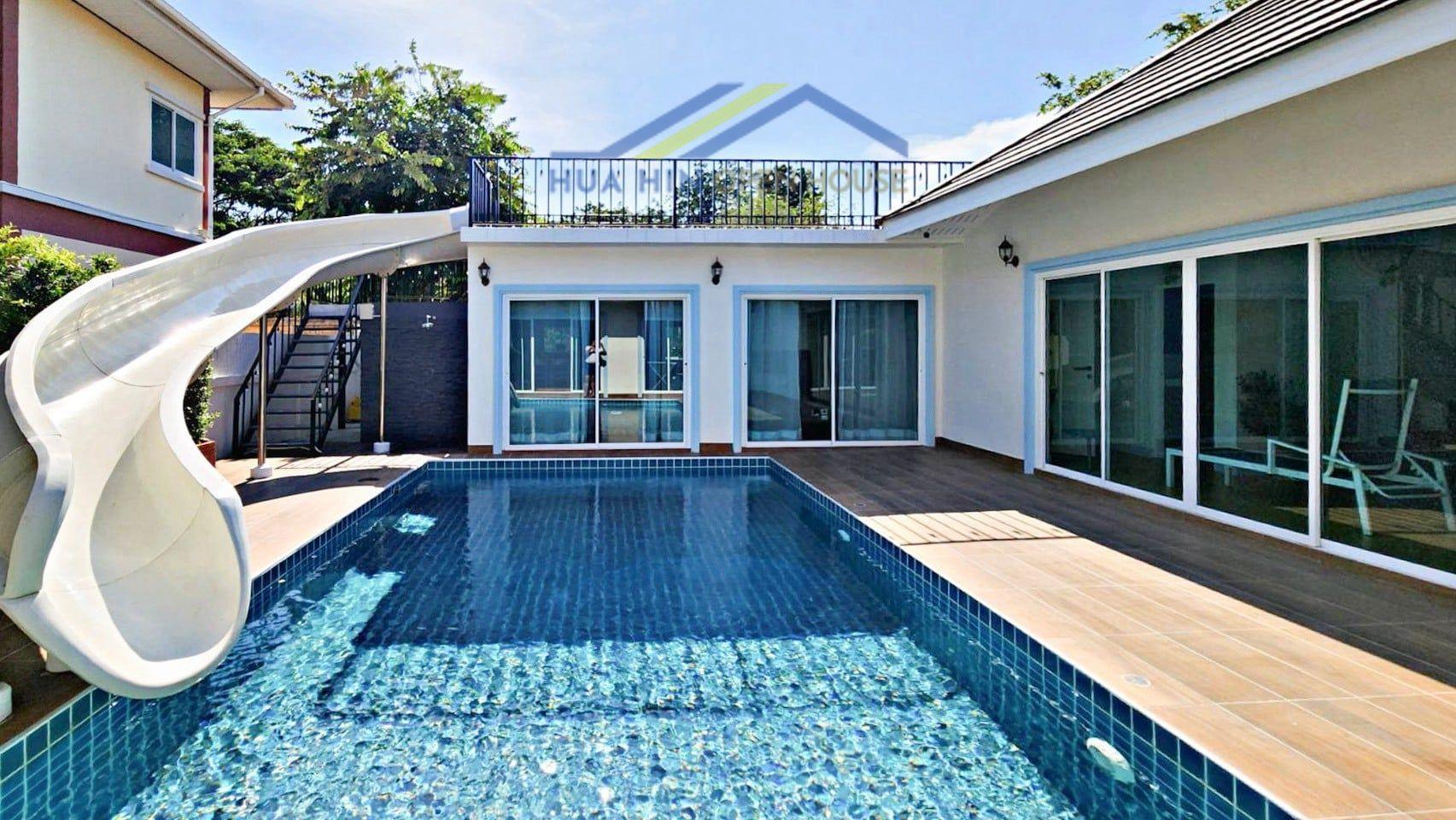 Bo Fai Hua Hin Private pool villa in Hua Hin with a water slide, spacious deck, and large glass doors leading to the interior.