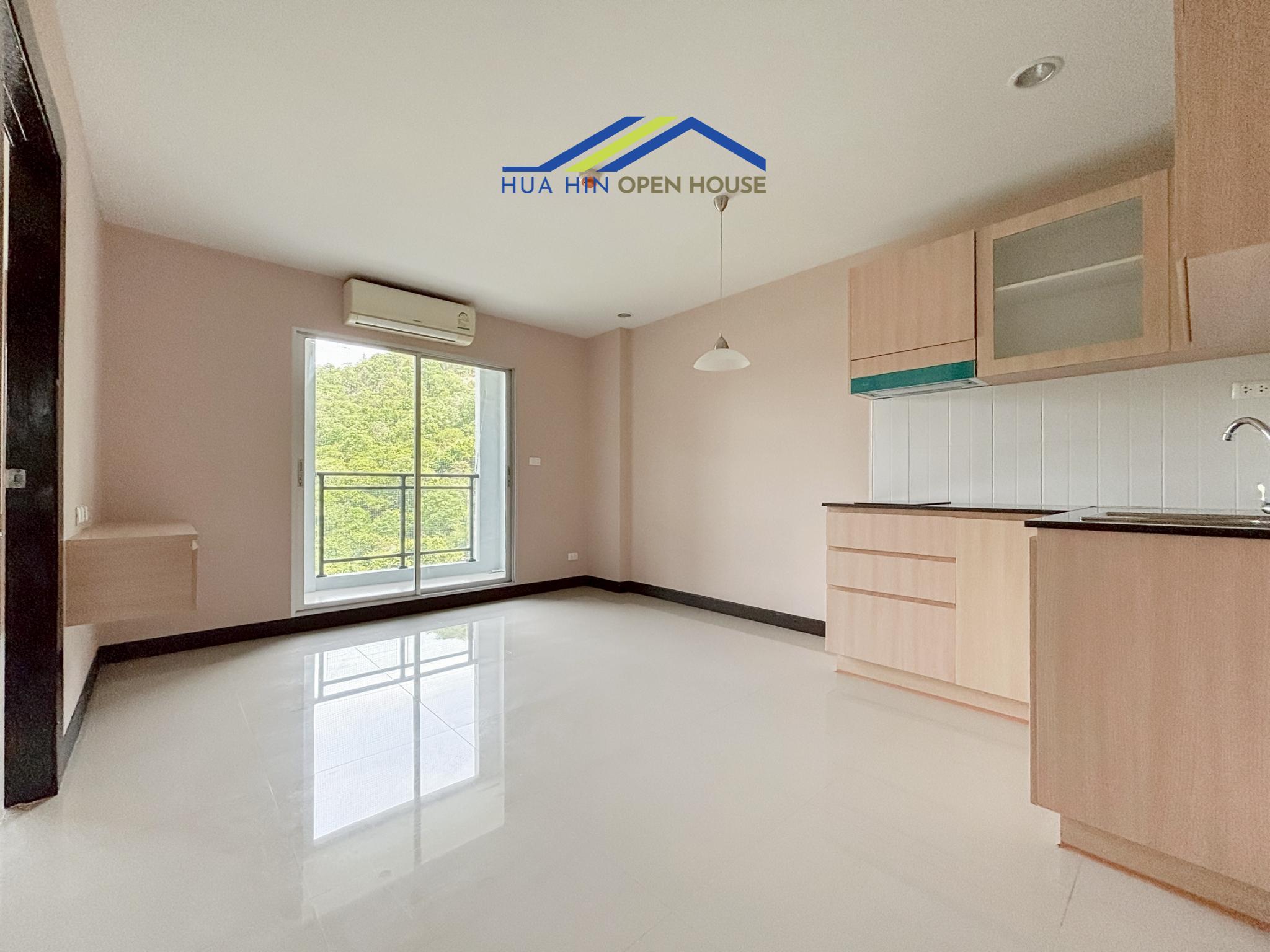 Bright, modern condo interior featuring a kitchen area and large window with mountain views in The 88 Condo.