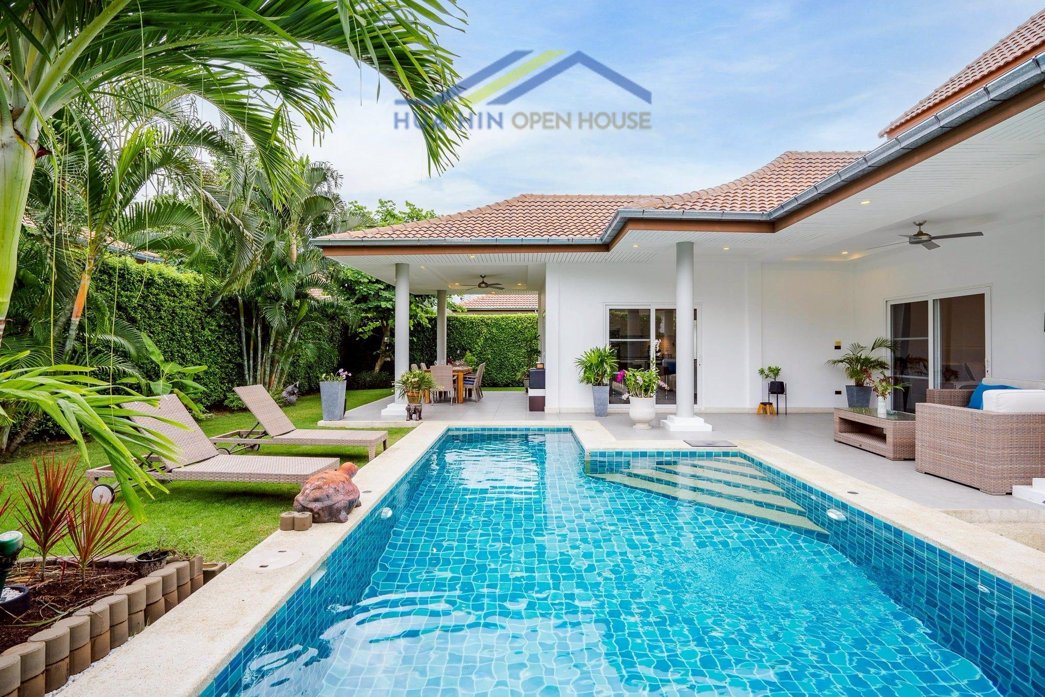 Modern 3-bedroom villa with a private pool, surrounded by lush greenery and outdoor seating area in Hua Hin.