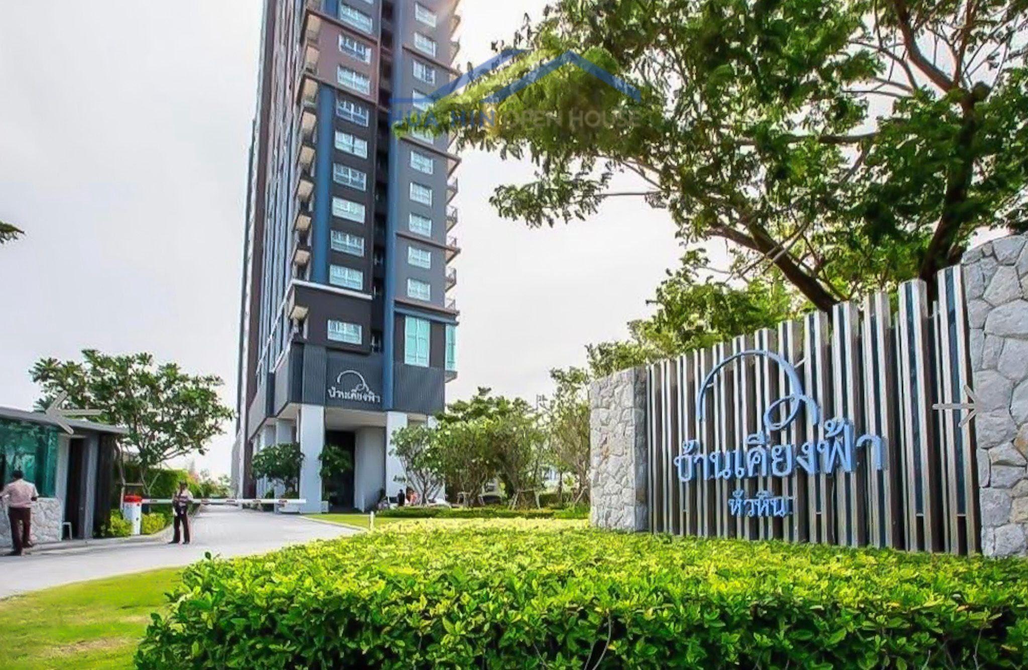 Modern high-rise building of Baan Kiang Fah surrounded by lush greenery in Hua Hin, Thailand.
