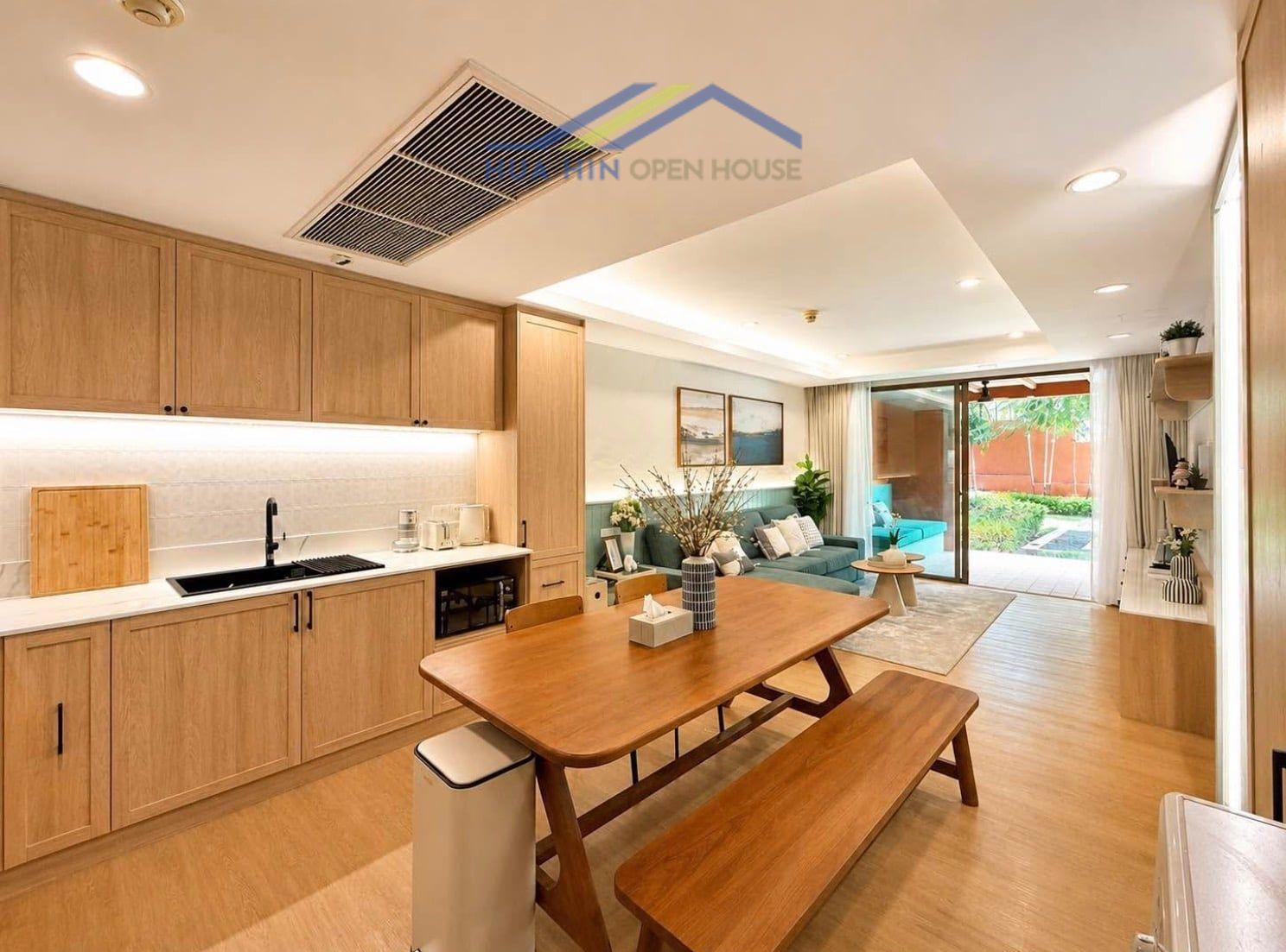 Stylish open-plan living area with modern kitchen, dining table, and access to a private outdoor space.