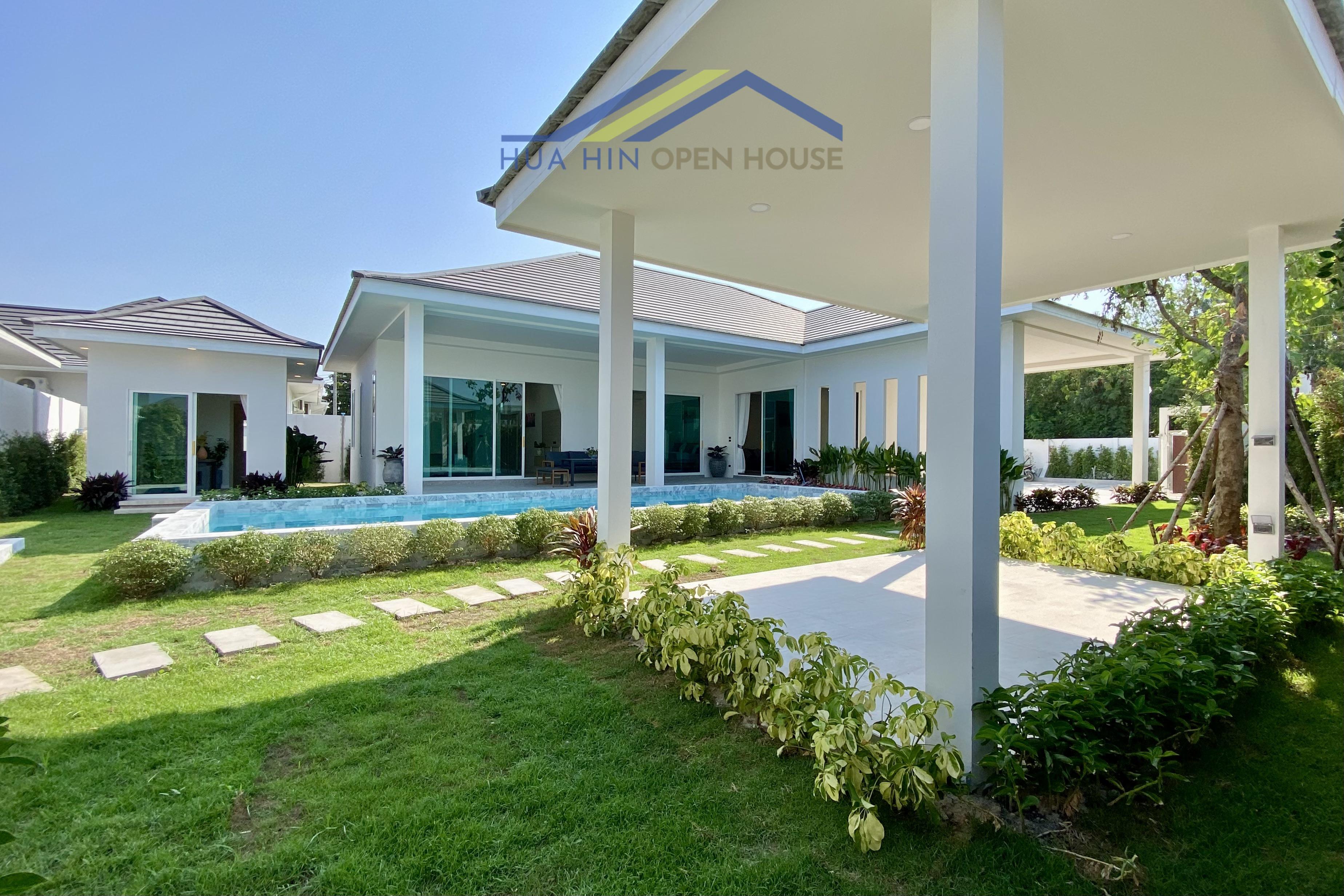 Modern pool villa in Hua Hin with lush gardens, outdoor seating area, and spacious living areas. Ideal for relaxation.
