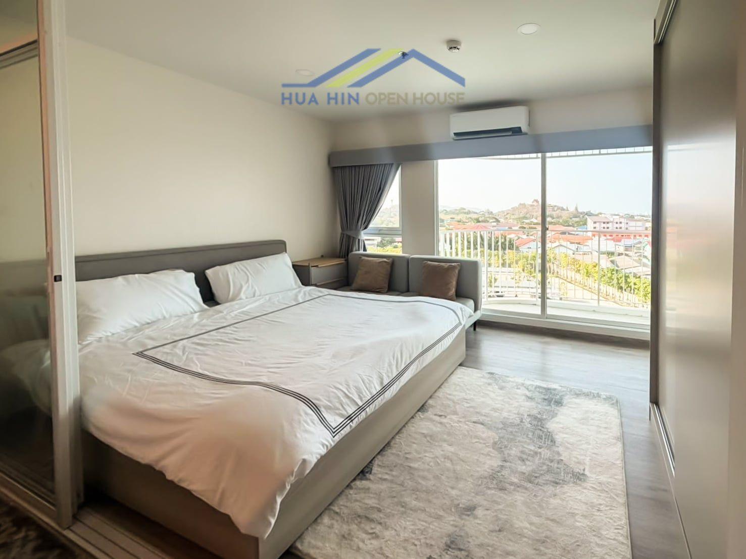 Spacious bedroom in a corner unit with mountain views, large windows, and modern furnishings at Supalai Blue Whale Hua Hin.