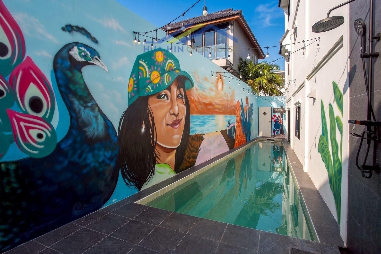 Townhouse for Sale in Khao Takiab Vibrant mural art alongside a sleek swimming pool in a modern townhouse courtyard in Khao Takiab, Hua Hin.