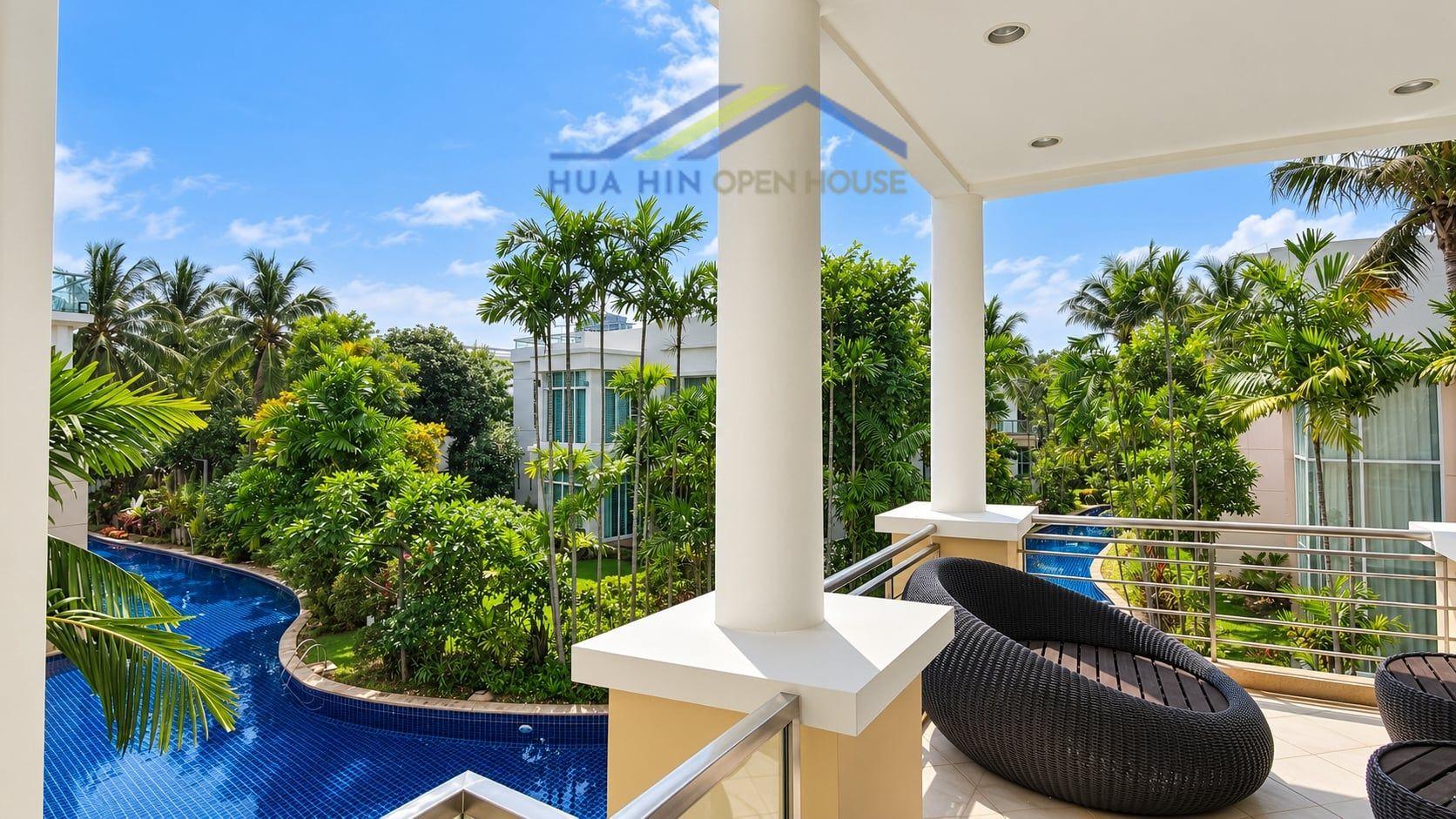 Spacious balcony overlooking lush greenery and a blue swimming pool at Hua Hin Blue Lagoon condo.