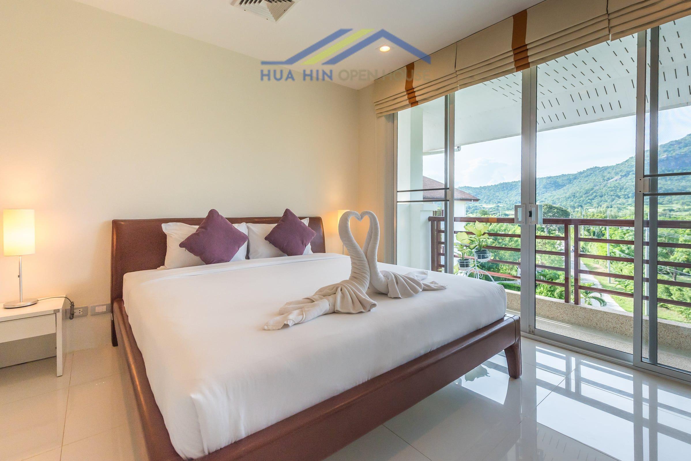 Spacious 2-bedroom condo with mountain views, featuring a cozy bed and elegant decor. Natural light floods the room.