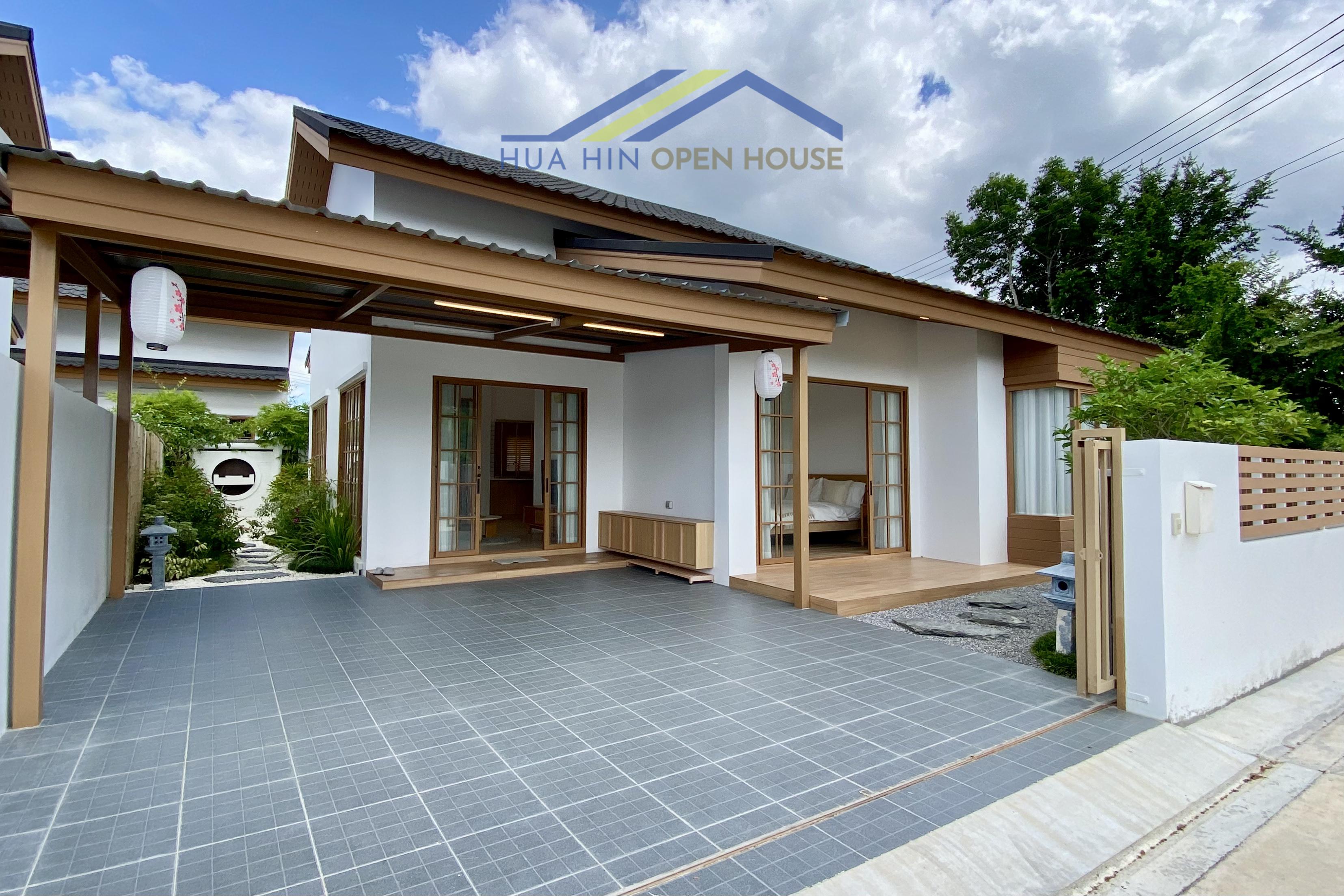Modern Japandi villa in Hua Hin with a spacious patio, wooden accents, and landscaped garden area. Ideal for tranquil living.