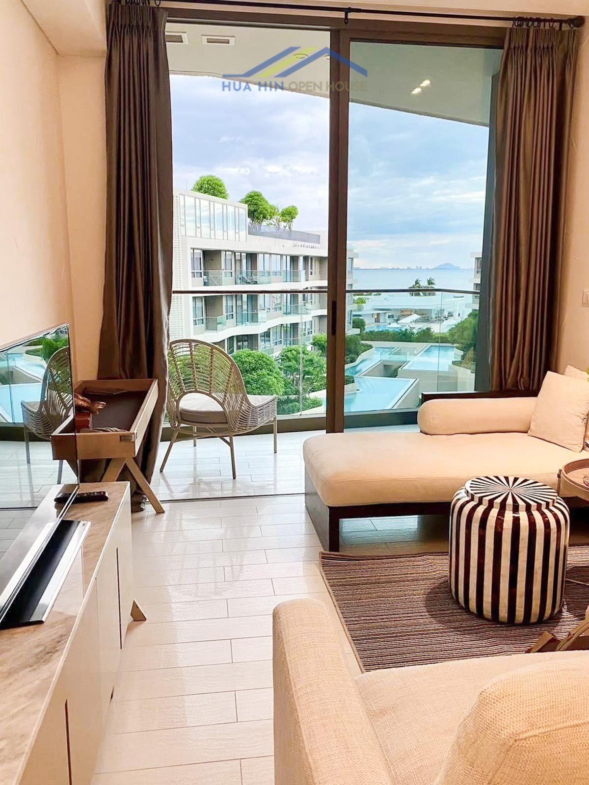 Modern living area in a sea view condo, featuring large windows, stylish furniture, and a cozy atmosphere.